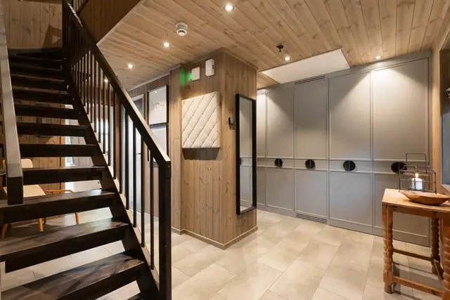 Vel inne blir vi ønsket velkommen i en langstrakt, pen entré med panel på veggene, downlights i himlingen og lysegrå fliser på gulv med vannbåren gulvvarme.