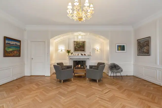 Den midtre stuen har himling med enkel rosett, og lune kvelder sikres av en elegant og oppmurt peis.