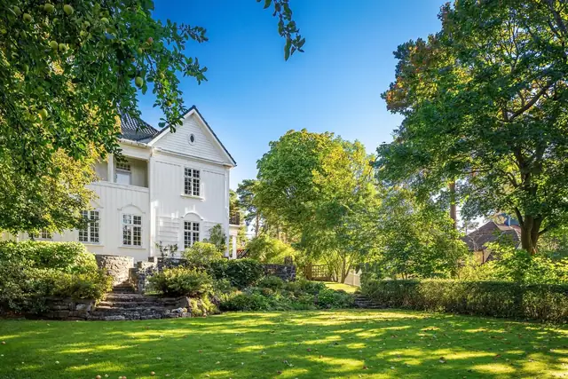 Majesteiske trær bidrar til å skape en privat oase, med mye boltreplass for både store og små. Tomten er på over 2,1 mål, frodig og parkmessig opparbeidet med velstelt beplantning.