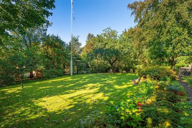Flaggstang er montert, og rundt om på eiendommen er det elegante lyktestolper for stemningsfull belysning kveldstid.