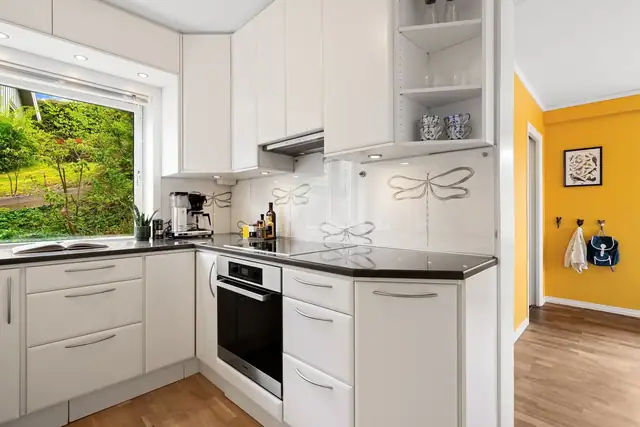 Kjøkkenet er utstyrt med integrert stekeovn, induksjonstopp, mikrobølgeovn, oppvaskmaskin, kjøleskap og slimline-ventilator. Fra spisestuen er det også inngang til en bod som er godt egnet som spiskammers og med god plass til fryser.