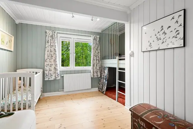 Det andre soverommet har plassbygd køyeseng og en hvit skyvedørsgarderobe.