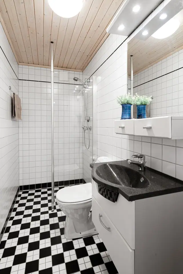 Det minste badet ligger vegg-i-vegg, og er fra 2000-tallet. Badet har gulvvarme og panelhimling med taklampe. Innredningen består av servant og servantskap, speil med hylle og overlys, toalett og en dusjnisje.
