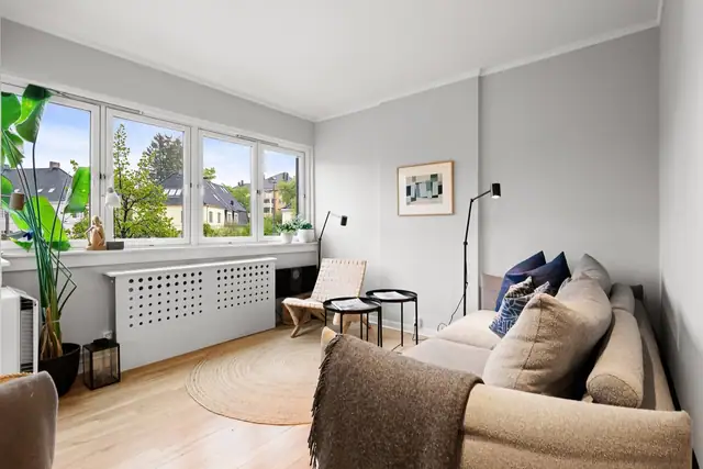 Stuen har originale eikebord, gråmalte vegger og et innebygd kott for praktisk oppbevaring.