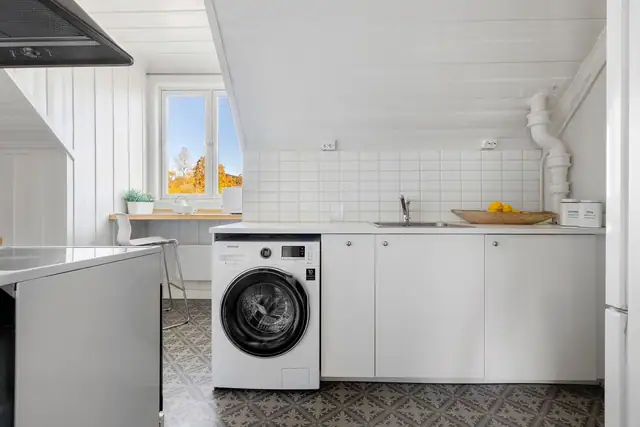 Kjøkkenet er utstyrt med komfyr, vaskemaskin og ventilator.