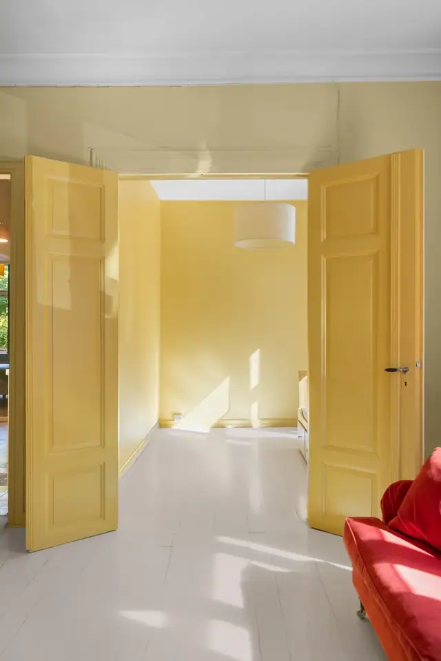 Fra stuen er det en gulmalt, tofløyet tredør inn til det ene soverommet.
