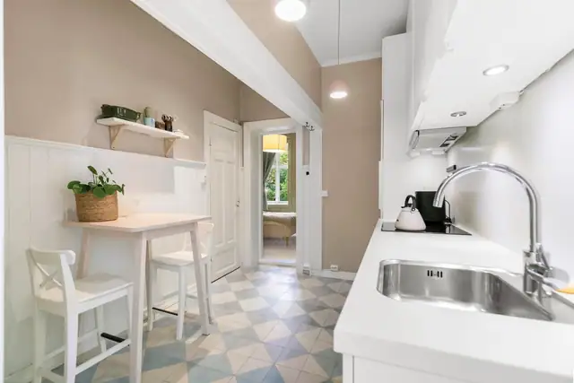 Kjøkkenet, som var nytt i 2014, har et tidsmessig og pent design med god skap- og benkeplass. Innredningen fra Kvik har hvite, glatte fronter, takhøye skap og hvit laminatbenkeplate med nedfelt kum i stål.