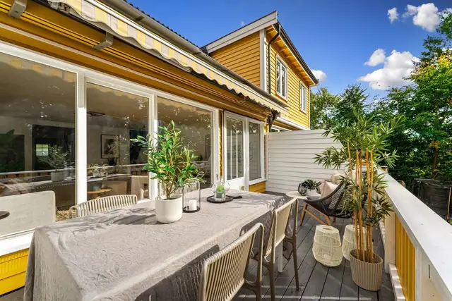 Balkongen har elektrisk markise, utsyn mot skogen og levegger på begge sider.