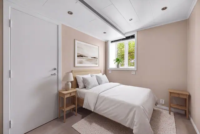 Soverommet i hybeldelen er luftig og pent, med beigemalte vegger, downlights i himlingen og enstavs laminat på gulvet. Bildet er digitalt stylet/AI-redigert og er ment som inspirasjon. Avvik vil forekomme.