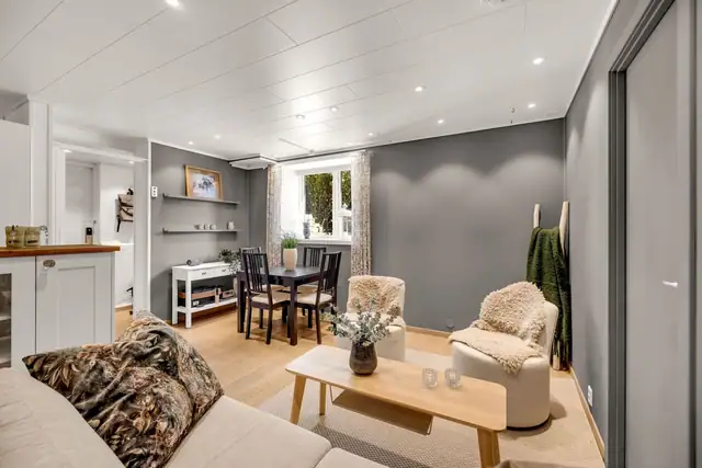 Her er det gråmalte vegger og downlights i hvit himling, og på gulvet er det parkett over vannbåren gulvvarme.