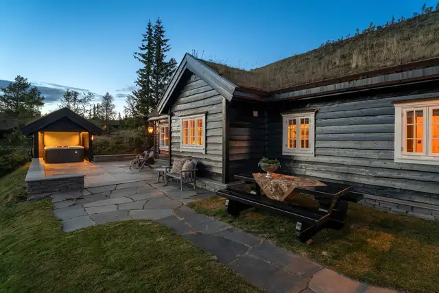 Hovedhytta, uteplassen og spabadet ligger samlet i et stemningsfullt terrassemiljø.