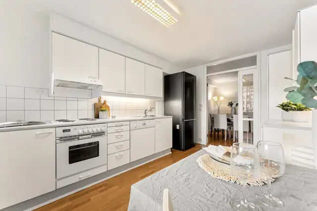 Kjøkkenet utstyrt med integrert stekeovn og koketopp, samt ventilator, benkestikk og opplegg for oppvaskmaskin.