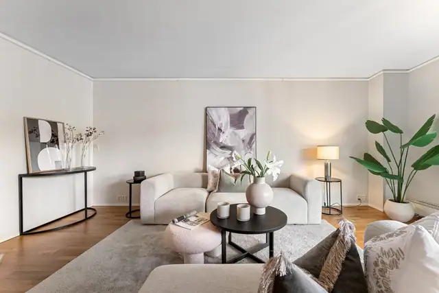 Stuen oppleves som lys, romslig og innbydende, og dagslyset som strømmer inn via store vinduer skaper en god atmosfære.