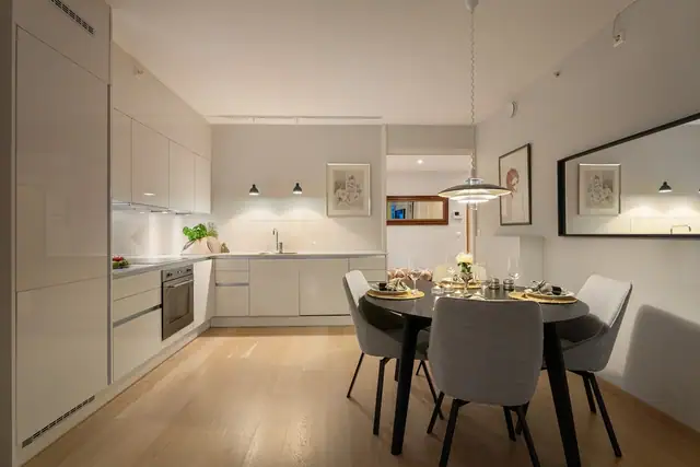 Kjøkkenet har et smakfullt og moderne design med gode benkeflater som innbyr til spennende kokkelering. Innredningen fra Crown har hvite høyglansfronter, takoppforede skap og hvit benkeplate i trykklaminat med underlimt kum i stål.