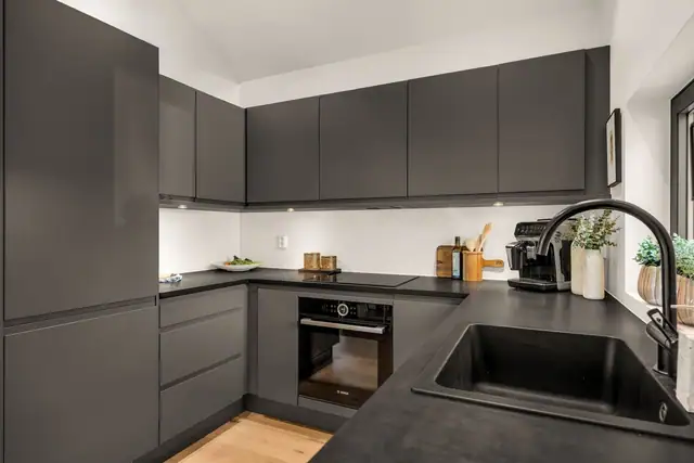 Stilrene materialvalg og en gjennomført kjøkkeninnredning gir et moderne uttrykk.