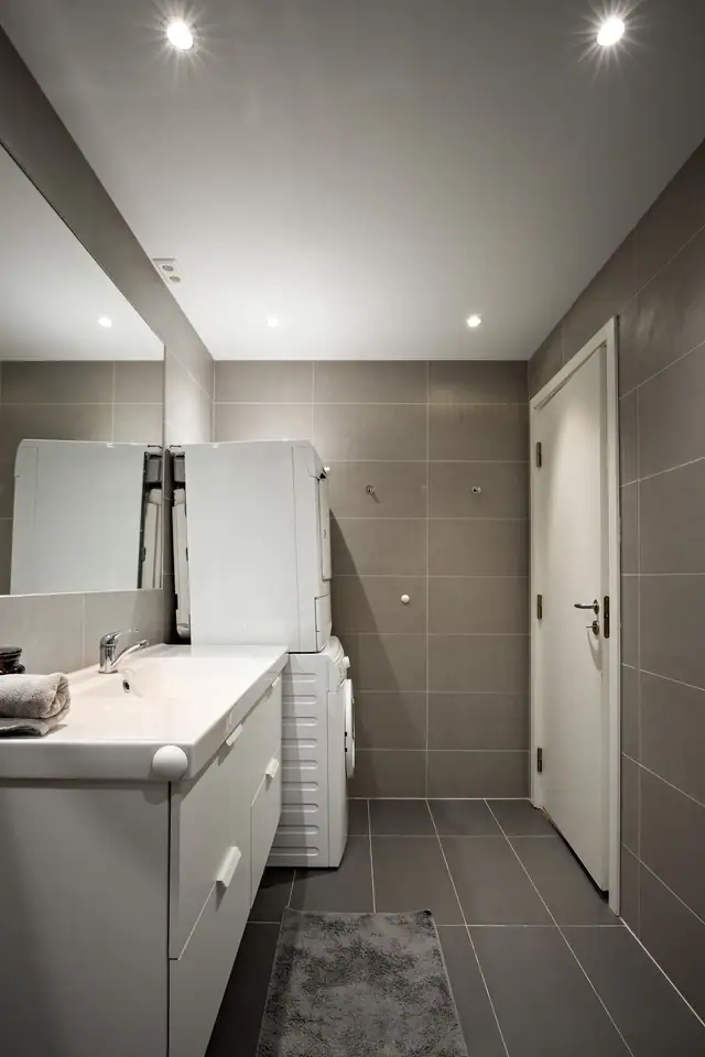 Flislagt bad med gulvvarme og downlights, plassert i tilknytning til soverommene.