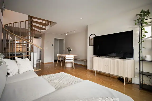Stuen har plass til både sofagruppe og spisebord, med en åpen løsning som samler oppholdsrommet.